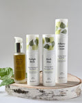 Set of four skincare products on a wooden tray with a gray background. Kasvi Beauty The Ritual Kit with daytime and nighttime serum, face oil, face cream moisturizer.